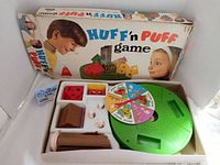 Full view of Huff 'n Puff board game in original box showing spinner, houses, and chimney components