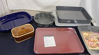 Photo of various cookware and bakeware including sheet pans, casserole dishes, and specialty baking pans