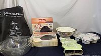Full view of all kitchen items including Pyrex bowls, cupcake stand, bean pot, colander, baking pans.