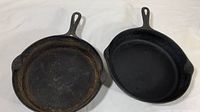 Pair of two Griswold cast iron pans on a white cloth background, showing overall size and shape.