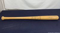 Full length of the wooden bat showing natural wood color and overall condition.