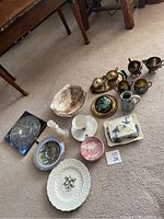 Overview of the box contents showing various silver cream and sugar sets, assorted china plates and bowls, and butter dish.