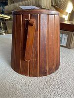 Side view of wooden container showing vertical slats and side handle