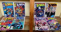 Photo of eight issues of The Uncanny X-Men comics laid out on a wooden surface, showing color covers with various characters and action scenes visible.