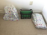 Black file folder holder with green folders, polka dot reusable bags folded beside it.