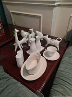 Overview of all porcelain animal figurines and serving pieces arranged on side table