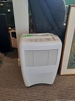 Front view of a white Whirlpool Gold humidifier showing vented front panel and curved base on carpet.