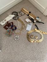 Overview photo of assorted costume jewelry including multiple bracelets, necklaces, two wristwatches, brooch, and earrings in various styles and colors.