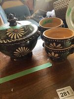 View of entire set showing large covered serving bowl and four individual bowls stacked together on wooden surface