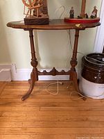 Full view of the solid wood side table with rectangular top and carved base showing legs and top.