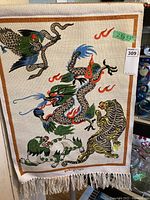 Full view of tapestry measuring 23 x 33 inches featuring dragon, tiger, snake, and phoenix with an orange border and white fringe.