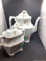 Tea pot and sugar bowl set with floral and gold decorative pattern, showing general appearance and condition