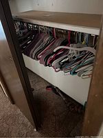 Closet rod with assorted plastic and wooden hangers in various colors