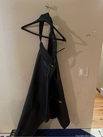 Leather motorcycle chaps hanging on a hanger showing overall look and material