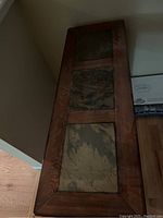 Top down view of the sofa table showing three slate tile insets and wooden trim.
