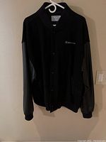 Front view of the black Motorola men's jacket with button closure and logo on chest.