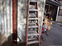 6 ft metal step ladder with red rails and silver treads in A-frame position