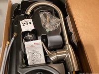 Moen 71850RB Brantford kitchen faucet in packaging, showing brushed nickel finish and pull-down spout.