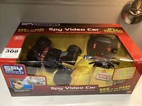 Front view of unopened Wild Planet Spy Gear Spy Video Car packaging showing the RC vehicle, headset, and remote controller inside clear plastic window.