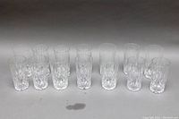 Front view showing all 15 tumblers arranged in two rows, clear crystal glass with cut pattern.