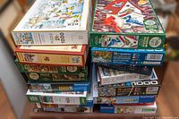 Stack of assorted puzzle boxes showing various brands and artwork