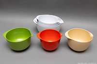 Six Rosti Denmark melamine mixing bowls in various colors and sizes arranged on gray background