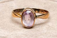 Front view of the 9K rose gold ring featuring an oval amethyst gemstone set in the center.