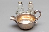 Photo of the sterling silver creamer and the crystal salt and pepper shakers placed behind it.
