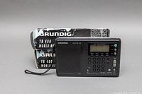 Grundig Yacht Boy 400 World Receiver radio with original box behind it, showing front view and keypad display.