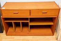 Front view of the teak media cabinet showing two drawers on top and divided shelving below.