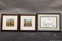 Photo of all three framed prints together showing the embossed swan print along with two cityscape prints.