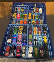Overhead view of 48 diecast vehicles in blue trays inside plastic case