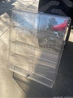 Overall view of the clear acrylic display case showing multiple shelves and front door.