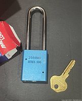 Close-up of single blue American Lock padlock showing embossed series and model numbers 2568MH Series 1100 with long silver shackle and brass-colored key
