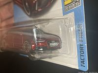 Close-up of the red metallic diecast model of the Audi RS 6 Avant inside its sealed bubble packaging, showing front grille detail and license plate.