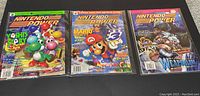 Three Nintendo Power magazines displayed side-by-side in protective sleeves.