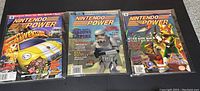 Front view of all three Nintendo Power magazines in protective sleeves showing cover art for Beetle Adventure Racing, Star Wars: Shadows of Empire, and Star Fox 64