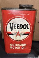 Front of vintage Veedol Outboard Motor Oil tin showing brand logo and product name with visible wear and surface rust.