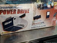 Photo of Chamberlain Power Drive 1/2 HP chain drive garage door opener box showing the product and included accessories