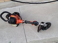 Side view of Echo SGM-266 gas grinder showing orange and black body, ergonomic handle, grinding wheel with safety guard, and fuel tank.