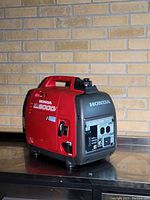 Side view of red and grey Honda EU2000i inverter generator on countertop