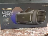 Photo of the product packaging showing the Wogofo M33 Pro Portable Wireless Speaker with stereo pairing and high bass features