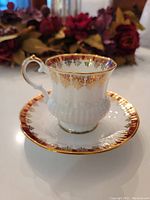 Tea cup and saucer set showing red band and gold filigree details, with no visible chips or wear