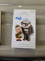 Photo of front of ornament box showing illustration of Carl and Russell characters from "UP"