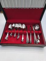 Full view of the 44-piece Lagostina flatware set with all pieces neatly arranged in the red-lined silverware holder box.