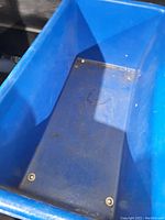 Blue plastic basket truck interior view showing dirt and metal brackets
