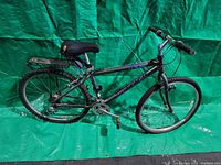 Full side view of dark gray Raleigh mountain bike showing frame, tires, saddle, and handlebars.