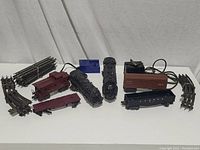 Lionel electric train set items including 2 locomotive engines, 4 train cars, 8 track sections, and 2 electric transformers. Items show dust and untested condition.