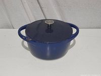 Closed view of 10 inch blue cast enamel Dutch oven with lid showing blue exterior and two handles.