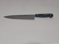 Full knife image showcasing blade and cracked black handle with three rivets.